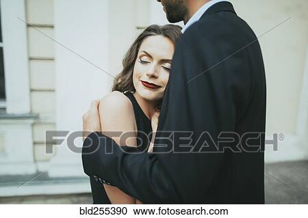 Stock Image - Portrait of smiling Caucasian couple hugging. Fotosearch