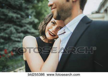 Stock Photograph - Portrait of smiling Caucasian couple hugging. Fotosearch
