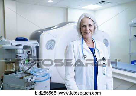 Stock Photography - Portrait of smiling Caucasian doctor near scanner. Fotosearch