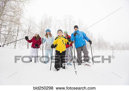 Stock Photo - Portrait of smiling Caucasian family snowshoeing. Fotosearch