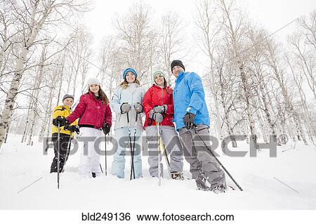 Stock Photograph - Portrait of smiling Caucasian family snowshoeing. Fotosearch