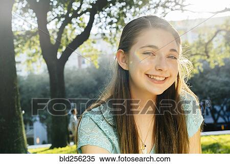 Stock Photography - Portrait of smiling Caucasian girl in park. Fotosearch