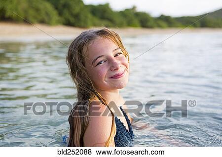 Stock Photo - Portrait of smiling Caucasian girl swimming. Fotosearch