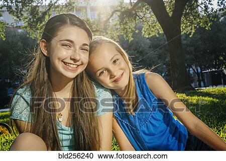 Portrait of smiling Caucasian girls in park View Large Photo Image Stock Image - Portrait of smiling Caucasian girls in park. Fotosearch