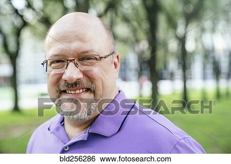 Stock Photograph - Portrait of smiling Caucasian man in park. Fotosearch