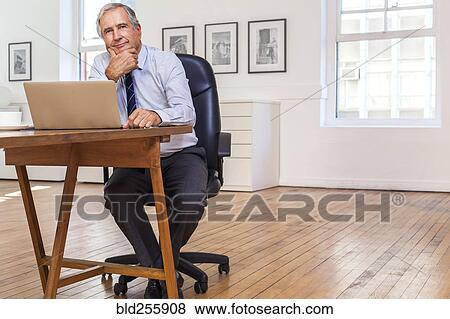 Portrait of smiling Caucasian businessman using laptop View Large Photo Image Stock Photo - Portrait of smiling Caucasian businessman using laptop. Fotosearch