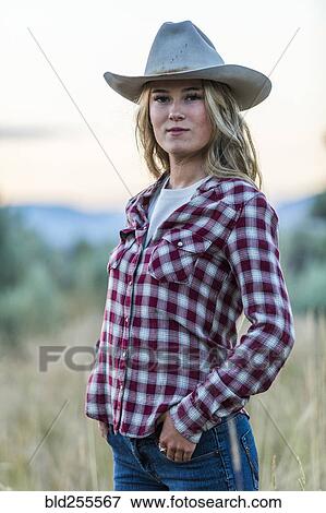Stock Photo - Portrait of smiling Caucasian teenage girl wearing cowboy hat at sunset. Fotosearch