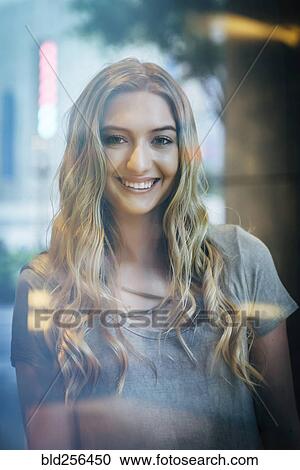 Portrait of smiling Caucasian woman behind window View Large Photo Image Stock Image - Portrait of smiling Caucasian woman behind window. Fotosearch
