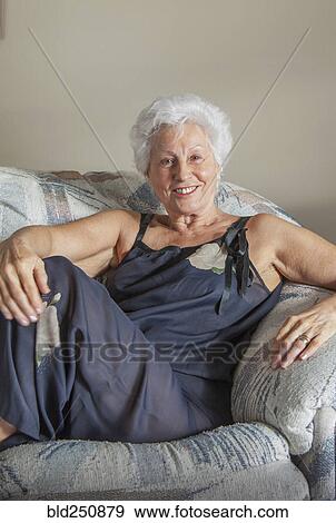 Portrait of smiling Caucasian woman sitting on sofa View Large Photo Image Stock Photo - Portrait of smiling Caucasian woman sitting on sofa. Fotosearch