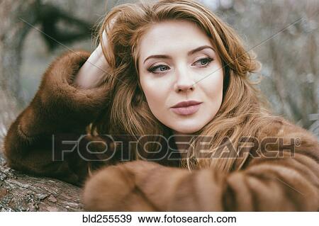 Stock Photo - Portrait of smiling Caucasian woman wearing fur coat. Fotosearch