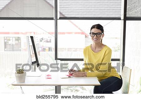 Stock Photography - Portrait of smiling Caucasian woman texting on cell phone. Fotosearch