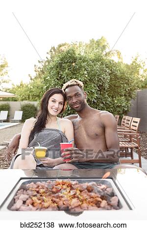 Portrait of smiling couple wrapped in towels near fire pit View Large Photo Image Stock Photo - Portrait of smiling couple wrapped in towels near fire pit. Fotosearch