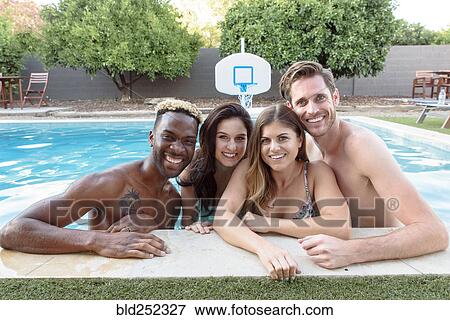 Portrait of smiling friends in swimming pool View Large Photo Image Stock Photo - Portrait of smiling friends in swimming pool. Fotosearch