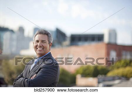 Portrait of smiling Hispanic businessman posing outdoors View Large Photo Image Stock Image - Portrait of smiling Hispanic businessman posing outdoors. Fotosearch