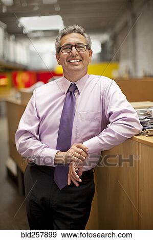 Portrait of smiling Hispanic businessman leaning on desk View Large Photo Image Stock Photo - Portrait of smiling Hispanic businessman leaning on desk. Fotosearch