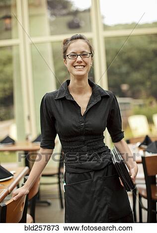 Portrait of smiling Hispanic waitress holding menus in restaurant View Large Photo Image Stock Image - Portrait of smiling Hispanic waitress holding menus in restaurant. Fotosearch
