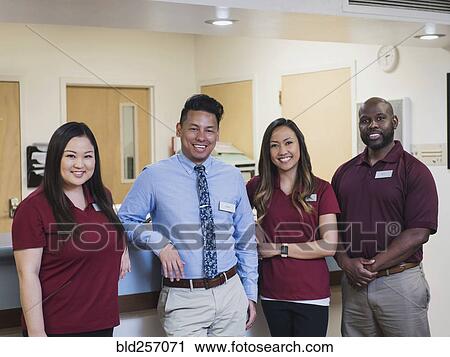 Stock Image - Portrait of smiling medical team in hospital. Fotosearch