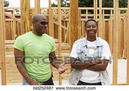 Stock Photo - Portrait of smiling men at construction site. Fotosearch