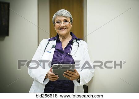 Portrait of smiling mixed race doctor using digital tablet View Large Photo Image Stock Photo - Portrait of smiling mixed race doctor using digital tablet. Fotosearch