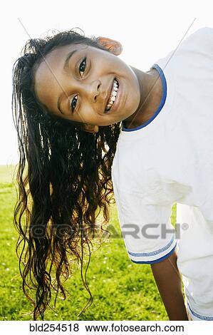 Stock Photo - Portrait of smiling mixed race girl with long hair. Fotosearch