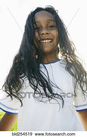 Stock Photo - Portrait of smiling mixed race girl with long hair. Fotosearch