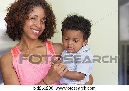 Stock Image - Portrait of smiling mixed race mother and baby son. Fotosearch