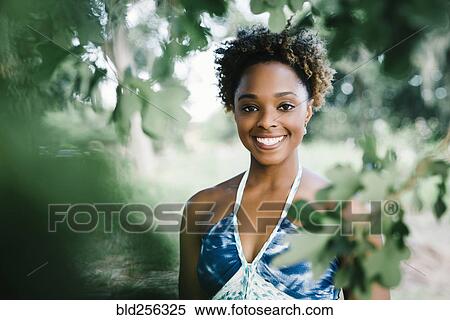 Portrait of smiling mixed race woman near tree View Large Photo Image Stock Photography - Portrait of smiling mixed race woman near tree. Fotosearch