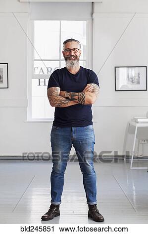 Stock Image - Portrait of smiling muscular Caucasian hipster man. Fotosearch
