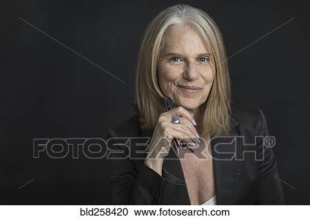 Portrait of smiling older Caucasian businesswoman holding eyeglasses View Large Photo Image Stock Image - Portrait of smiling older Caucasian businesswoman holding eyeglasses. Fotosearch