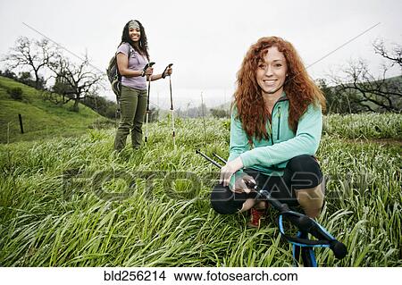 Portrait of smiling women hiking with walking sticks View Large Photo Image Picture - Portrait of smiling women hiking with walking sticks. Fotosearch