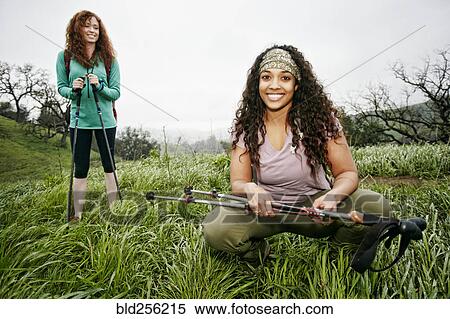 Stock Photography - Portrait of smiling women hiking with walking sticks. Fotosearch