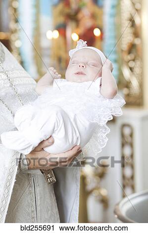 Priest holding baby girl in church View Large Photo Image Stock Image - Priest holding baby girl in church. Fotosearch