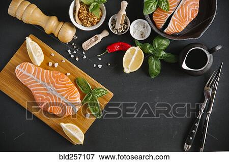 Raw salmon on cutting board with ingredients View Large Photo Image Stock Photo - Raw salmon on cutting board with ingredients. Fotosearch