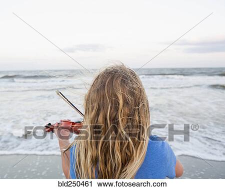 Rear view of Caucasian girl playing violin at beach View Large Photo Image Stock Image - Rear view of Caucasian girl playing violin at beach. Fotosearch