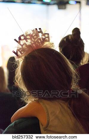 Stock Image - Rear view of Caucasian girl wearing birthday headband. Fotosearch