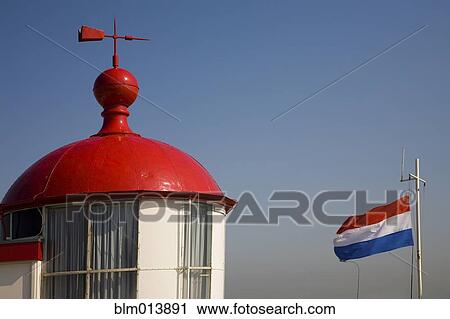 Stock Image - Red roof with weather vane. Fotosearch