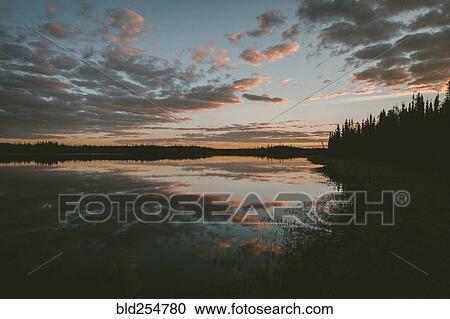 Stock Image - Reflection of clouds in water at sunset. Fotosearch