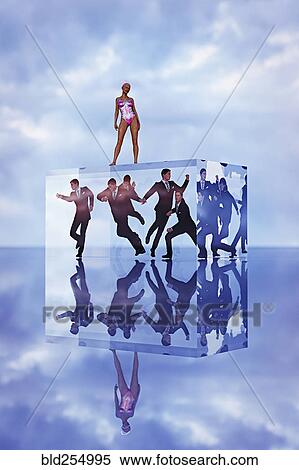 Stock Photography - Robot woman standing on cube with businessmen trapped inside. Fotosearch
