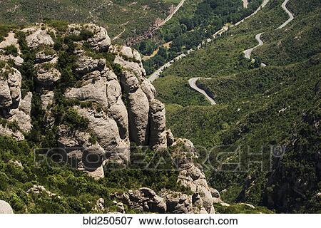 Stock Photo - Rock formations overlooking winding road. Fotosearch