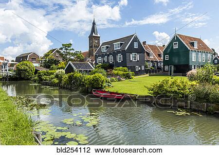 Stock Image - Rowboat in canal at traditional village. Fotosearch