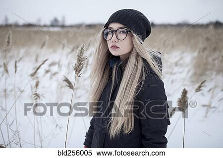 Stock Photography - Serious Asian girl standing in field in winter. Fotosearch