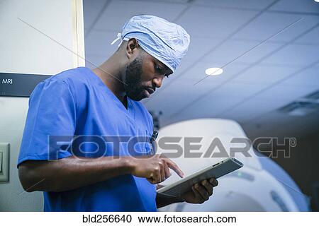 Serious black nurse using digital tablet View Large Photo Image Stock Image - Serious black nurse using digital tablet. Fotosearch