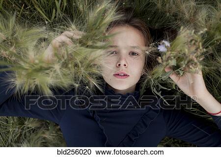 Serious Caucasian girl laying in field View Large Photo Image Stock Image - Serious Caucasian girl laying in field. Fotosearch