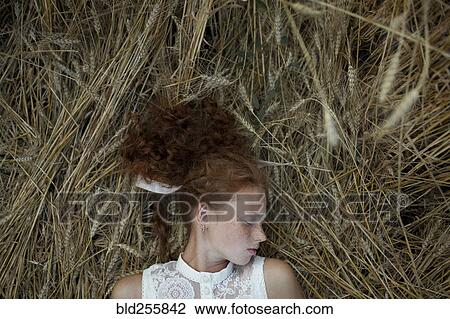 Serious Caucasian girl with freckles laying in wheat View Large Photo Image Stock Image - Serious Caucasian girl with freckles laying in wheat. Fotosearch