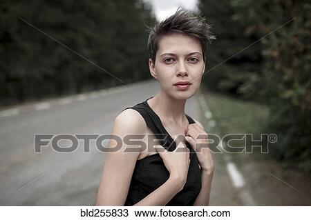 Stock Image - Serious Caucasian woman standing in road. Fotosearch