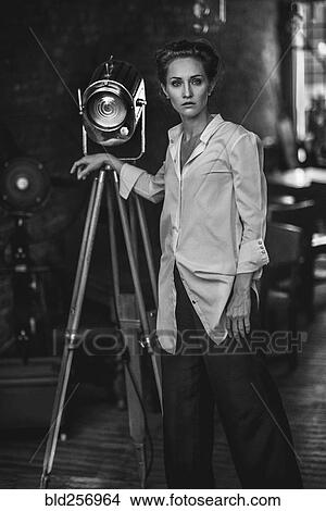 Picture - Serious Caucasian woman standing near light. Fotosearch