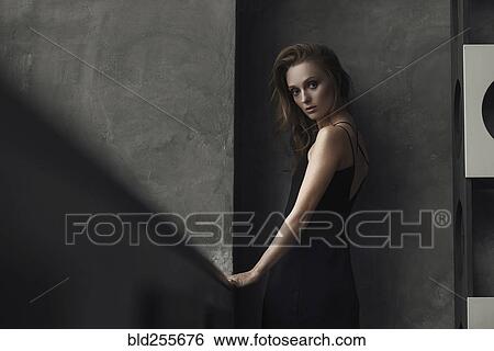 Serious Caucasian woman standing near wall View Large Photo Image Stock Photograph - Serious Caucasian woman standing near wall. Fotosearch