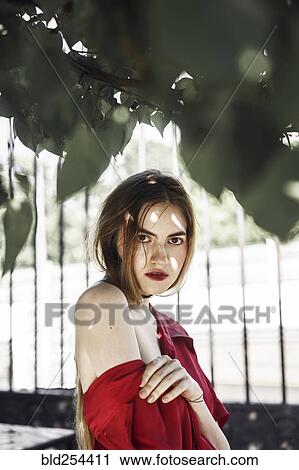 Stock Image - Serious Caucasian woman under tree branch. Fotosearch