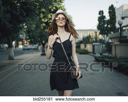 Stock Image - Serious Caucasian woman walking in the city. Fotosearch