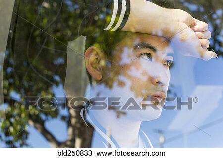Stock Image - Serious Chinese man leaning on window. Fotosearch